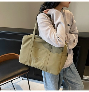 Olive green nylon tote bag with long shoulder straps and spacious exterior pocket