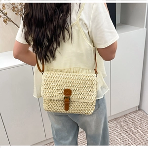 Vue arrière d'un mannequin portant un sac bandoulière en paille avec détails cuir