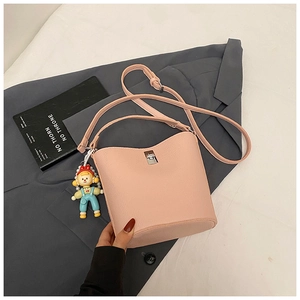 Pink pebble leather bucket bag featuring a silver twist lock and cute cartoon doll charm