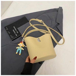 Detail of light yellow bucket bag with lychee texture leather and silver twist lock