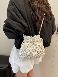 Handmade beige woven macrame bucket bag with drawstring closure and wooden beads detail