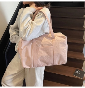 Close-up of pink nylon tote bag featuring white embroidered VIGOUR VIVID text
