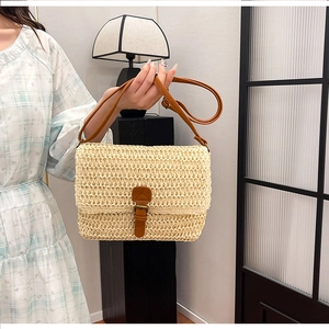 Détail de la texture en raphia tissé et de la bandoulière en cuir de ce sac bandoulière