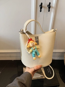 Beige lychee pattern leather bucket bag with silver twist lock and cute blue pendant