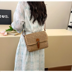 Détail du sac bandoulière vintage en paille kaki avec sangle en cuir et texture tissée