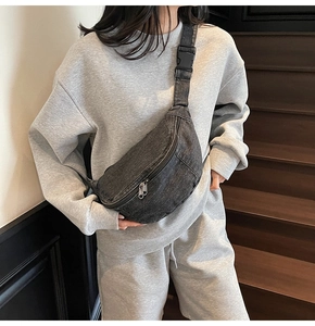 Detailed close-up of dark grey washed denim chest bag with sturdy dual metal zippers