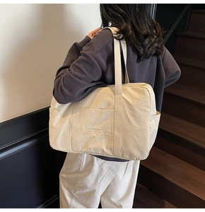 Close-up of off-white oversized canvas tote with vivid embroidery for daily travel