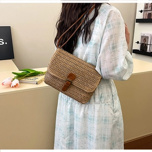 Détail d'un sac bandoulière en paille avec lanière en cuir dans un décor minimaliste