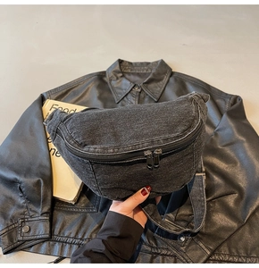 Close-up of washed gray denim sling bag showing fabric texture and metal dual zippers