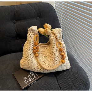 Detailansicht der hohlen Häkel-Strohtasche mit gelben Ringen und Holzperlengriffen