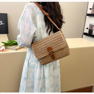 Détail d'un sac bandoulière en paille tressée avec bandoulière en cuir pour le style de plage