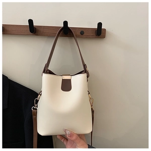 Close-up of contrast bucket bag with gold hardware and removable shoulder strap