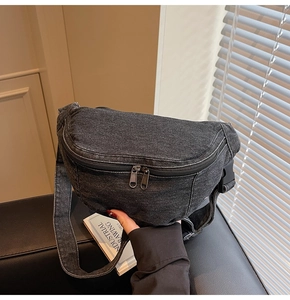 Detail of vintage dark grey denim chest bag with metallic zipper and adjustable strap