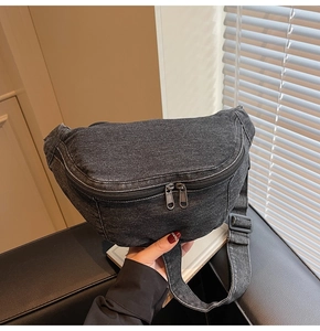 Detail view of black denim chest bag with sturdy dual zippers and adjustable shoulder strap