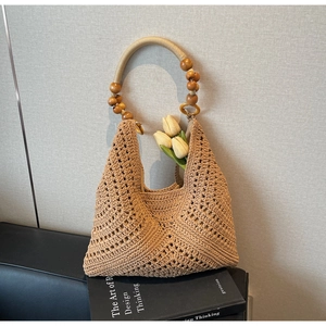 Details der hohlen Strohtasche mit Holzperlengriff und Tulpendekoration im Freien