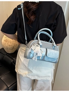 Chic light blue bowling bag with lace bow and pearl charm shown on female model