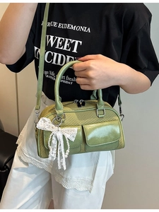 Chic green woven bowling bag with lace bow and pearl charm for crossbody wear