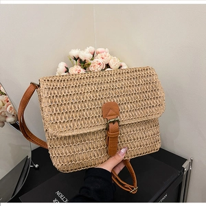 Détail de la texture en paille et de la bandoulière en cuir d'un sac carré vintage