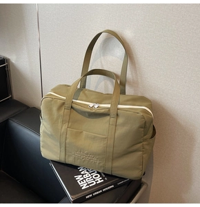 Detail view of large olive green tote bag with zipper and multi-pocket functional design