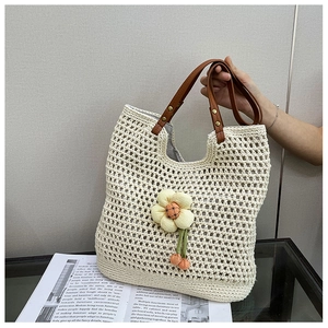 Dettaglio della borsa tote a rete con manici in pelle marrone e decorazione floreale 3D