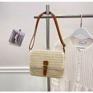 Vue détaillée de la texture en paille tressée et bandoulière en cuir avec boucle rétro