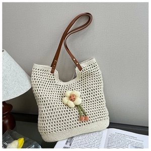 Dettaglio della borsa tote in tessuto traforato con fiore 3D e spalline in pelle