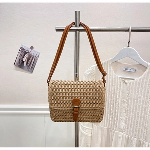 Détail du sac bandoulière en paille tressée avec bandoulière cuir et boucle métal