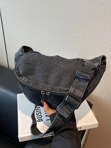 Minimalist black denim half-moon chest bag with adjustable strap and vintage wash finish