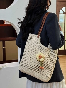 Borsa tote beige all'uncinetto con manici in pelle marrone e ciondolo a fiore