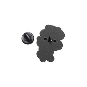 Detail view of the enamel pin's black matte back with a metal needle and rubber clutch