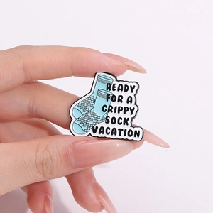 Minimalist enamel pin featuring blue grippy socks with ready for a vacation slogan