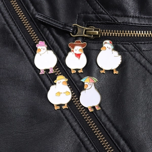 Set of five cute cartoon white duck enamel pins on a black leather jacket lapel