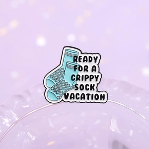 Blue enamel pin of grippy socks with Ready for a Grippy Sock Vacation text