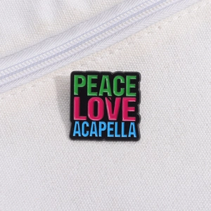 Macro detail of Peace Love Acapella colorful enamel badge on white canvas fabric