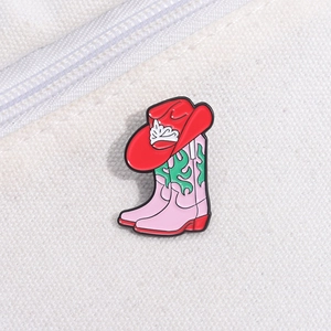 Détail de la broche en émail botte de cowboy rose et rouge sur un sac en toile blanc