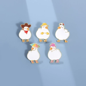 Set of five cute cartoon enamel duck pins with colorful hats and boots on blue background