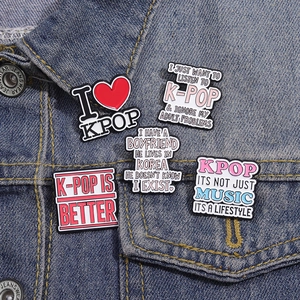 Set of five K-POP enamel badges with motivational phrases on a blue denim jacket