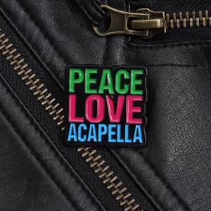 Black enamel Peace Love Acapella brooch pinned on a black leather jacket texture