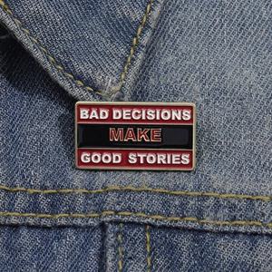 Bad Decisions Make Good Stories enamel pin badge on blue denim jacket fabric