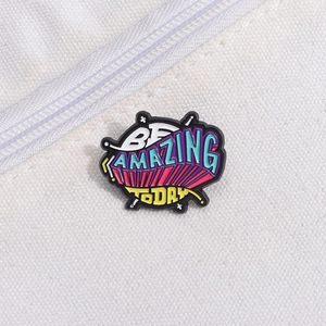 Close-up of Be Amazing Today colorful enamel pin attached to white canvas fabric