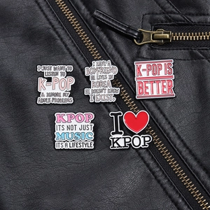 Detail of K-POP quote enamel pins pinned on a black leather jacket for streetwear styling