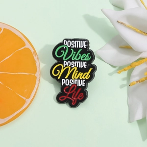 Positive Vibes Mind Life inspirational enamel pin on a fresh green background
