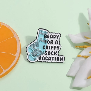 Cute blue socks enamel pin with Ready For A Grippy Sock Vacation text on green background