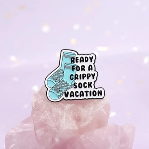 Blue and white enamel mental health pin with Ready for a grippy sock vacation text
