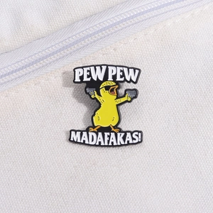 Macro shot of cartoon yellow duck enamel pin with 'PEW PEW' text on canvas background