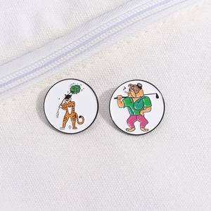 Detail of cartoon enamel pins featuring a tiger and bulldog playing golf on white canvas