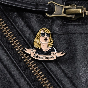 Detail of enamel pin with 'Help Me I'm Poor' text pinned to a black leather jacket lapel