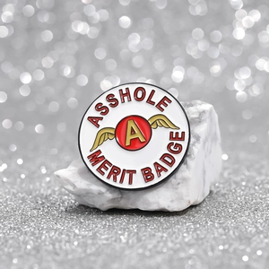 Lustiger Asshole Merit Badge Emaille-Pin mit Flügeln auf Marmor mit Bokeh-Lichteffekt