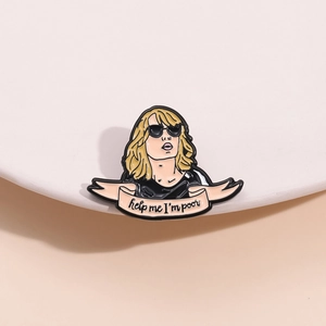 Macro shot of an enamel pin featuring a sunglasses-wearing woman with help me I'm poor banner