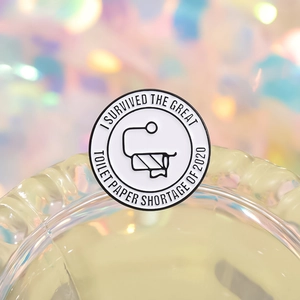 Round enamel pin with I Survived The Great Toilet Paper Shortage 2020 lettering
